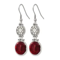 Pair of silver-toned drop earrings with ornate oval filigree tops and deep red oval gemstone bottoms, suspended from shepherd's hook wires.
