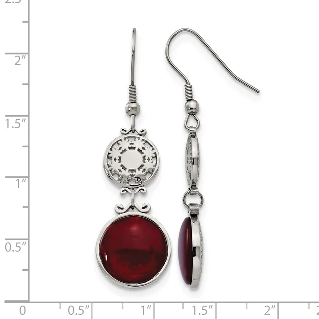 A pair of silver-toned dangle earrings with ornate circular filigree tops and deep red gemstone bottoms, displayed against a ruler showing measurements up to 2.5 inches.