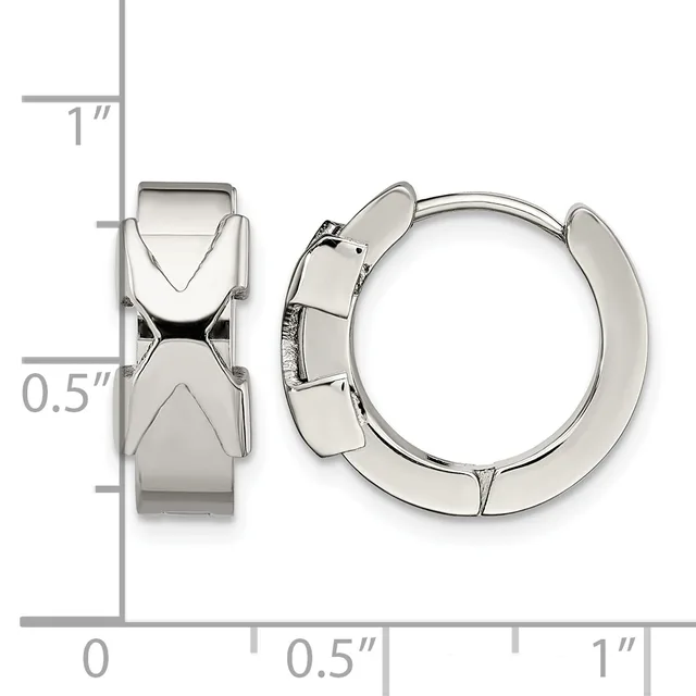 A pair of polished silver-toned chunky hoop earrings with geometric X-shaped designs on the front, shown next to a measurement ruler.