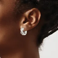 A person wearing a small silver chunky curved hoop earring in their earlobe, shown in profile against a neutral background.