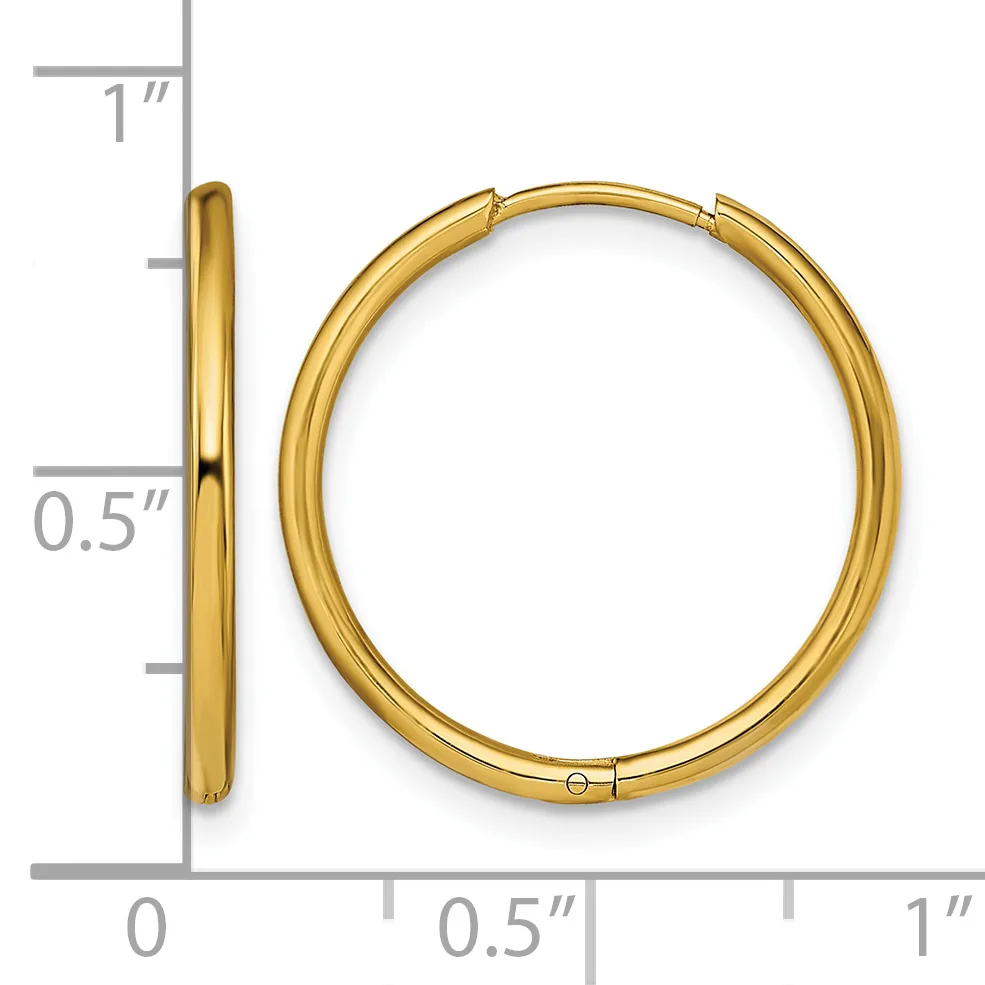 A pair of gold-toned hoop earrings with a polished finish displayed against a ruler showing measurements up to one inch.