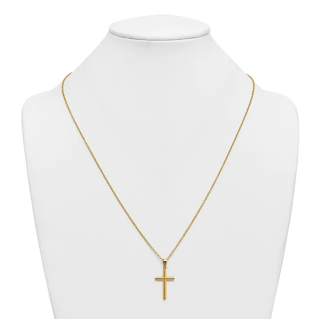 A gold-toned cross pendant hangs from a delicate gold chain on a white bust display form.