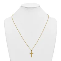 A gold-toned cross pendant hangs from a delicate gold chain on a white bust display form.
