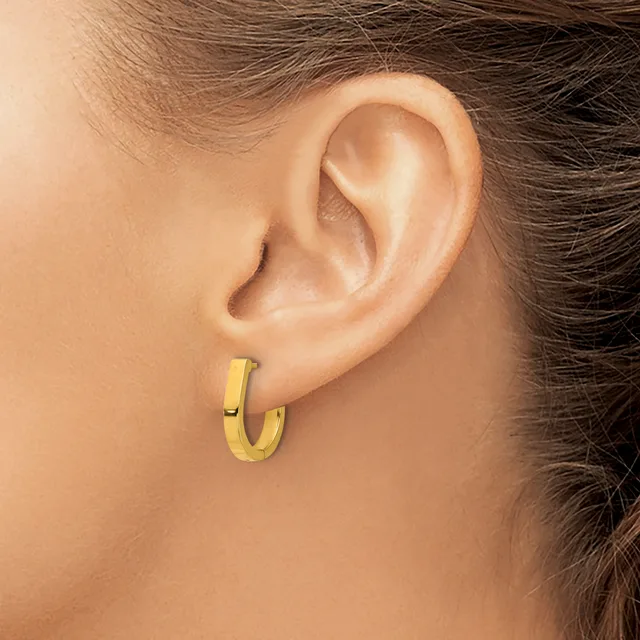 A woman wearing a small gold hoop earring in her earlobe, shown in profile against her neck and shoulder.