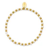 A beaded bracelet alternating between gold-toned and white pearl beads with a small oval gold charm tag attached at the top.