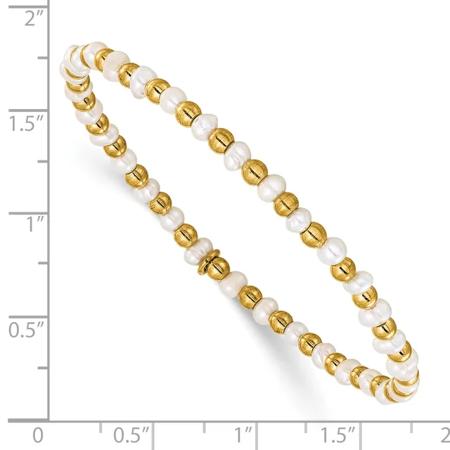A pair of gold-tone and white pearl beaded stretch bracelets displayed on a measurement scale showing they are approximately 2 inches in diameter.