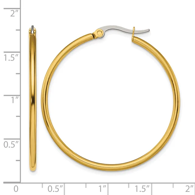 A pair of polished gold hoop earrings with hook closures, displayed against a ruler showing they measure approximately 1.5 inches in diameter.
