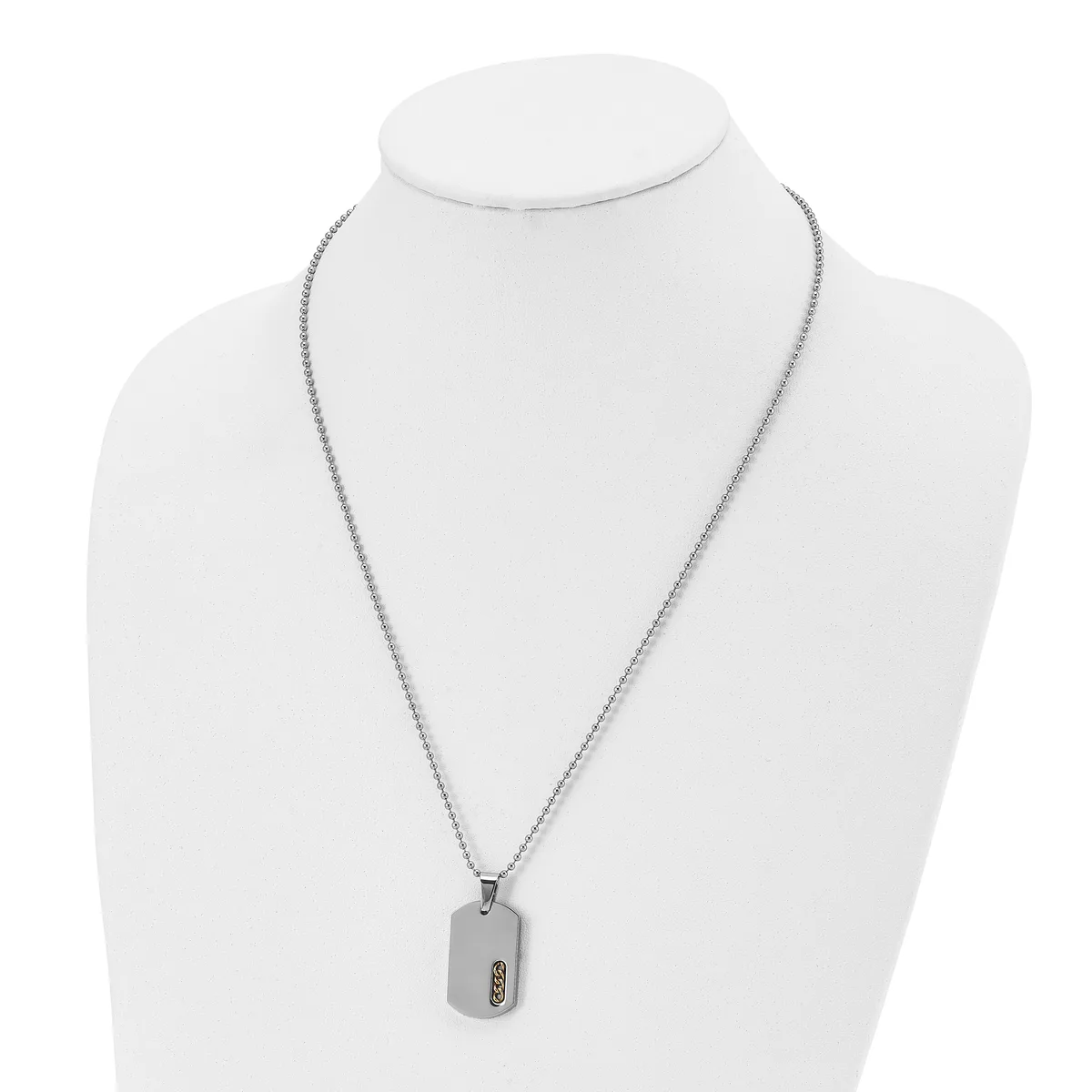 A stainless steel necklace with a fine box chain and a rectangular dog tag pendant featuring a small stamped hallmark, displayed on a white bust form.