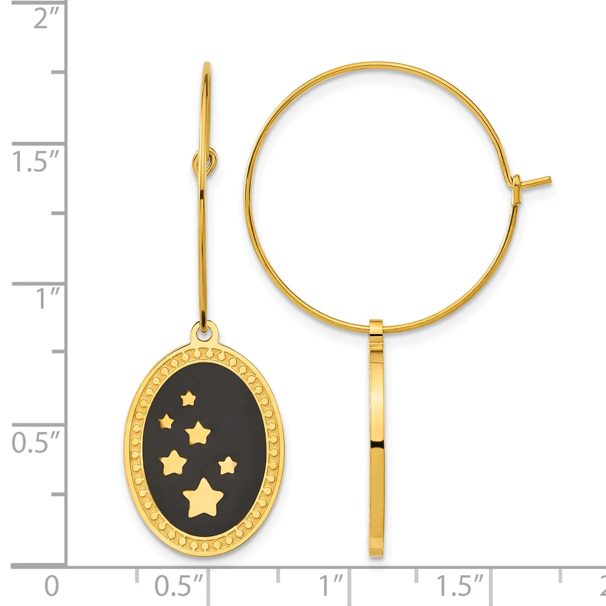 Gold hoop earrings with an oval pendant featuring a black enamel face decorated with gold stars, displayed next to a ruler showing measurements up to two inches.
