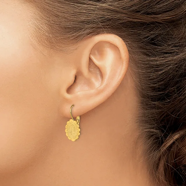 A woman wearing a yellow textured oval pendant earring on a hook, shown from the side view of her ear and neck.
