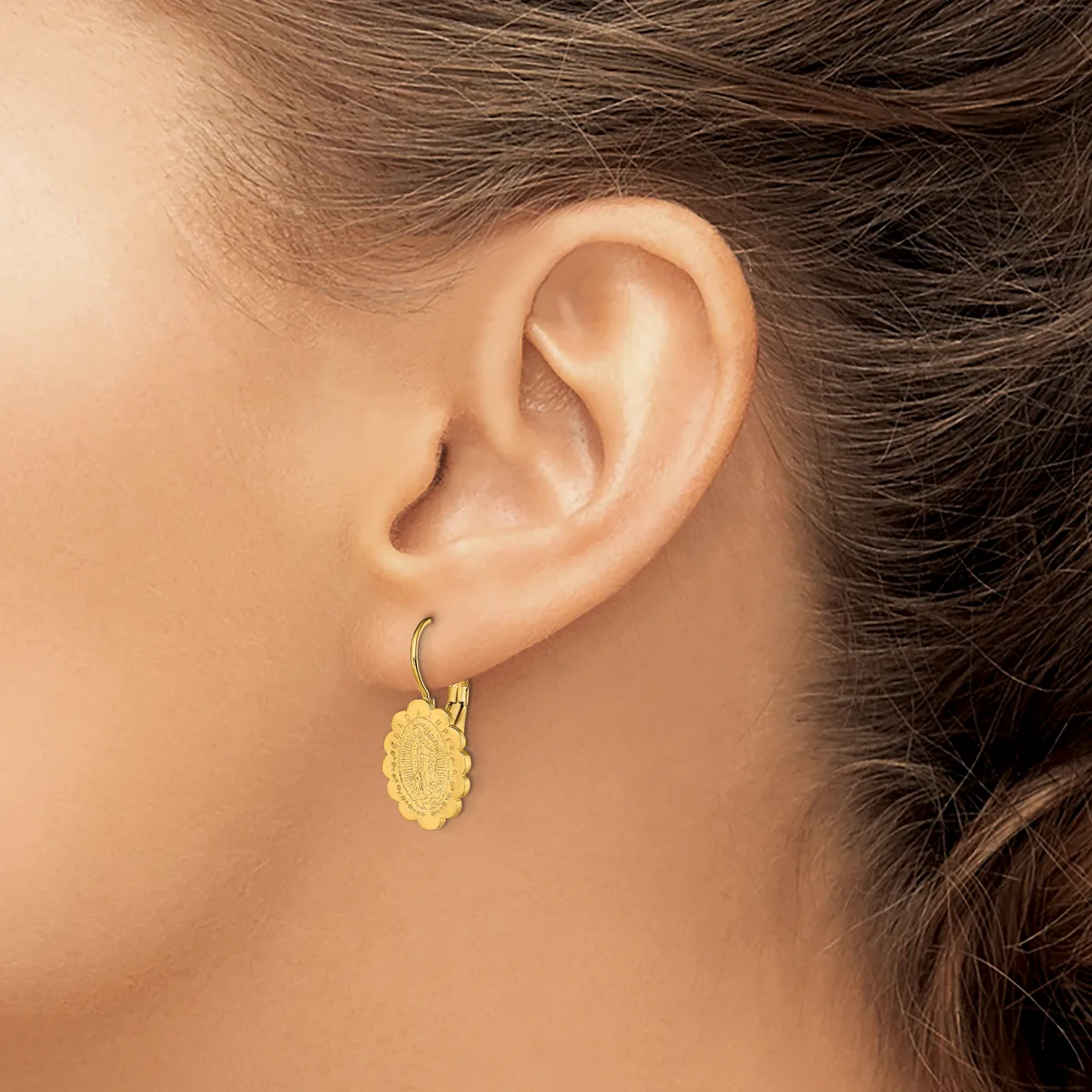 A woman wearing a yellow textured oval pendant earring on a hook, shown from the side view of her ear and neck.