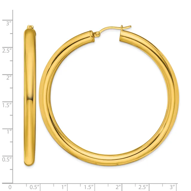 Pair of polished gold-tone hoop earrings with a chunky tubular design, shown against a measurement scale indicating approximately three inches in length.