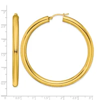 Pair of polished gold-tone hoop earrings with a chunky tubular design, shown against a measurement scale indicating approximately three inches in length.