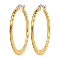 A pair of polished gold-toned oval hoop earrings with hinged closures, shown against a white background.