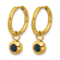 Pair of gold-toned hoop earrings with small spherical charms featuring dark blue oval stones set in gold bezels.