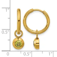 Pair of gold hoop earrings with small dangling peridot gemstone charms, displayed next to a measurement scale.