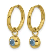 A pair of gold hoop earrings with blue gemstone charms hanging from the bottom.