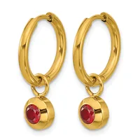 A pair of gold hoop earrings with oval loops and small spherical charms featuring red gemstones suspended from the bottom.