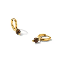 A pair of gold hoop earrings, each with a small brown stone bead attached, shown from two angles against a white background.