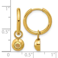 Pair of gold-colored huggie hoop earrings with detachable champagne-colored stone pendants, shown next to a measurement scale.