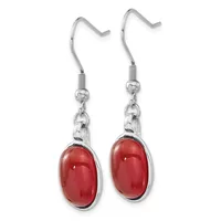 A pair of silver-toned dangle earrings with red oval cabochon stones suspended from fish hook wires.