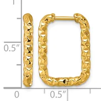 A pair of gold-colored rectangular hoop earrings with a textured, hammered surface finish, shown against a measurement scale.