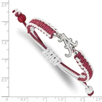 A burgundy and white braided cord bracelet with a silver fleur-de-lis charm, displayed against a measurement scale showing approximately 2.5 inches in length.
