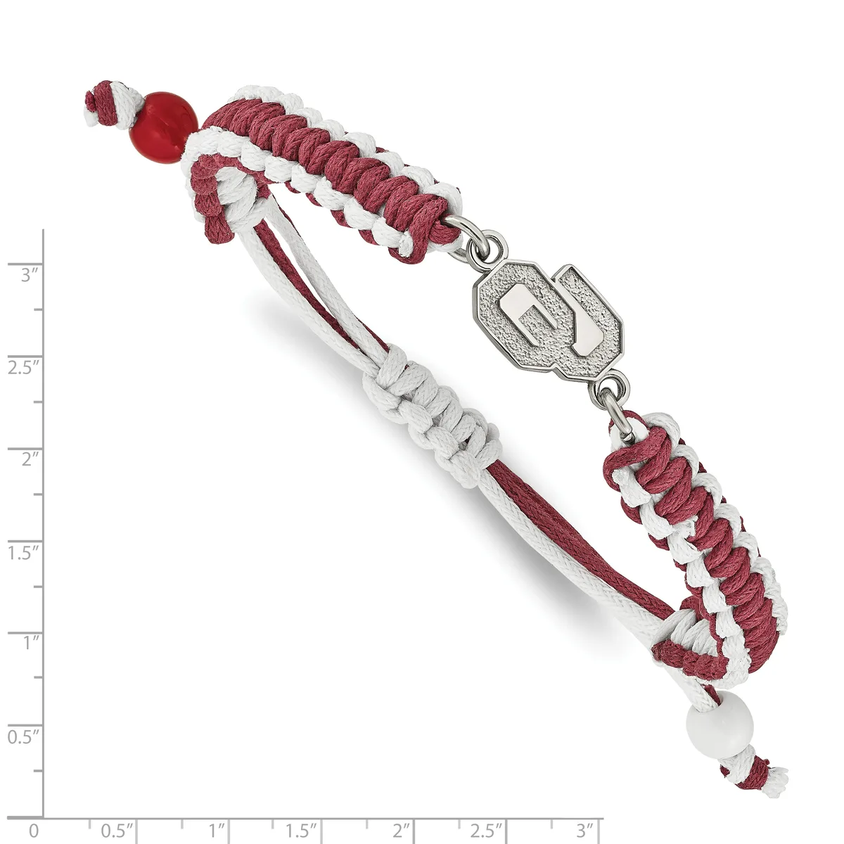 A burgundy and white braided bracelet with a silver rectangular charm connector and beaded ends, shown against a measurement scale.
