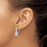 A silver crescent-shaped earring with a rectangular crystal stone hangs from a pierced earlobe.