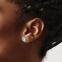 A close-up side view of a person's ear wearing a small square stud earring with a cushion-cut diamond or crystal stone set in white metal.