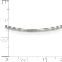 A curved metal tube or coil with a grid pattern shown against a measurement scale ranging from 0 to 1.5 inches in height and width.