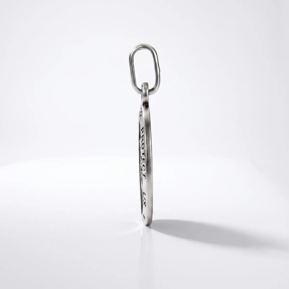 A silver elongated oval keychain with engraved text hangs from an oval metal ring against a white background.