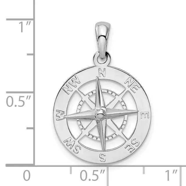 A polished silver compass rose pendant with cardinal directions marked around the outer circle, shown next to a ruler indicating it is approximately one inch in diameter.