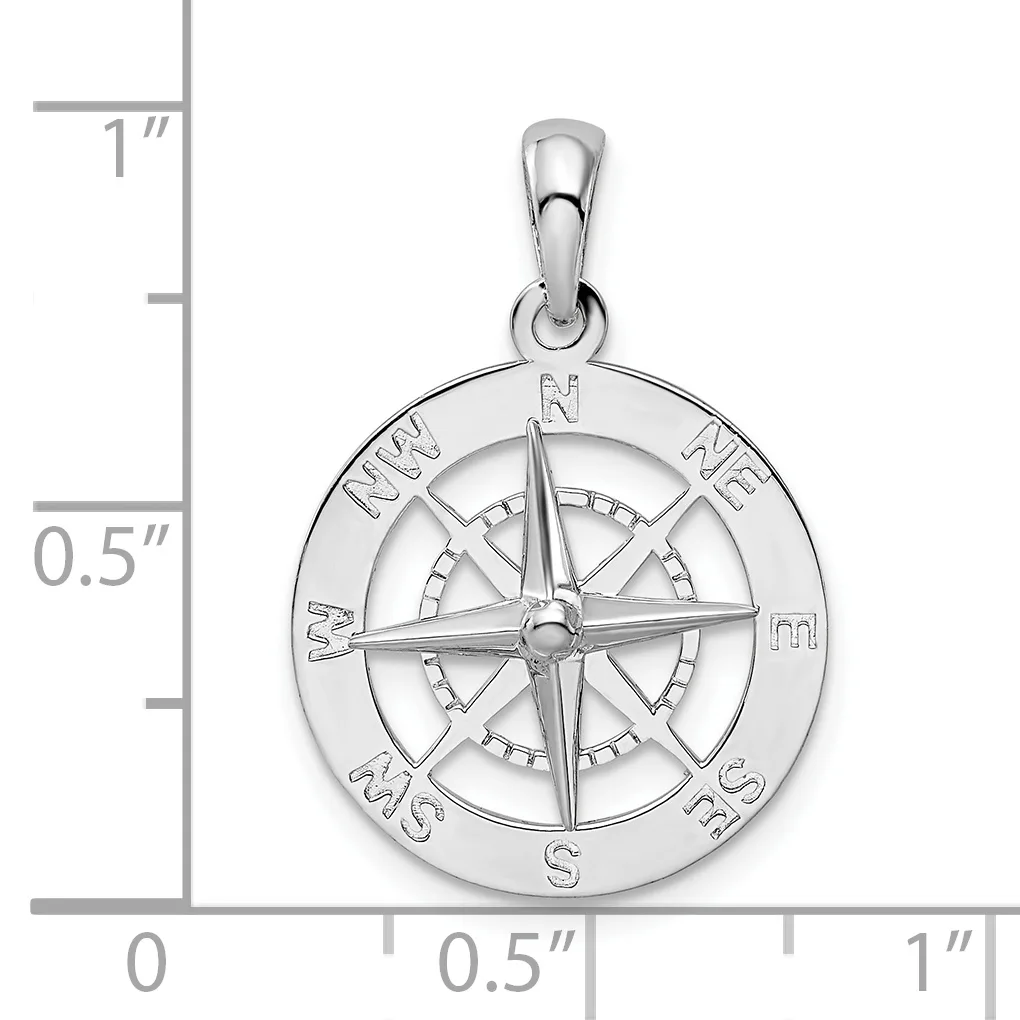 A polished silver compass rose pendant with cardinal directions marked around the outer circle, shown next to a ruler indicating it is approximately one inch in diameter.
