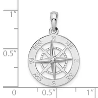 A polished silver compass rose pendant with cardinal directions marked around the outer circle, shown next to a ruler indicating it is approximately one inch in diameter.
