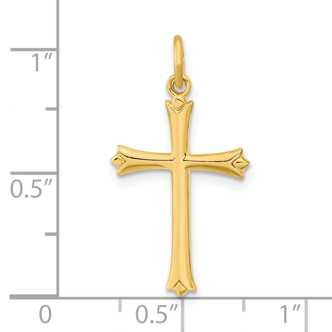 A gold cross pendant with flared ends and decorative points, shown against a measurement scale indicating approximately one inch in height.