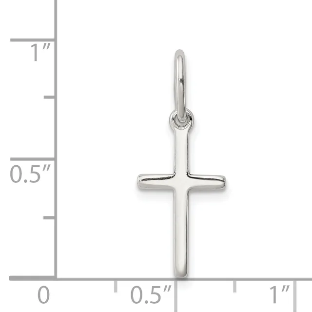 A polished silver cross pendant with a looped bail at the top, shown against a measurement scale indicating approximately one inch in height.