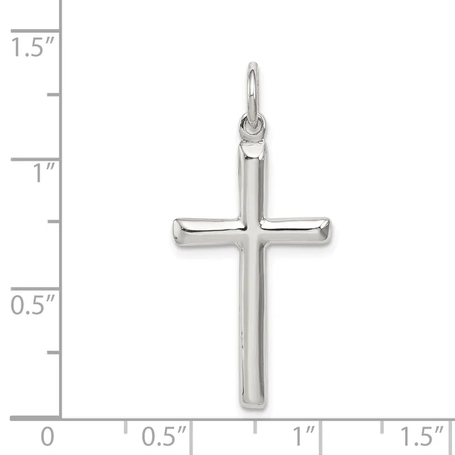 A polished silver cross pendant with a hollow center displayed against a ruler showing it measures approximately one inch wide and one and one-quarter inches tall.