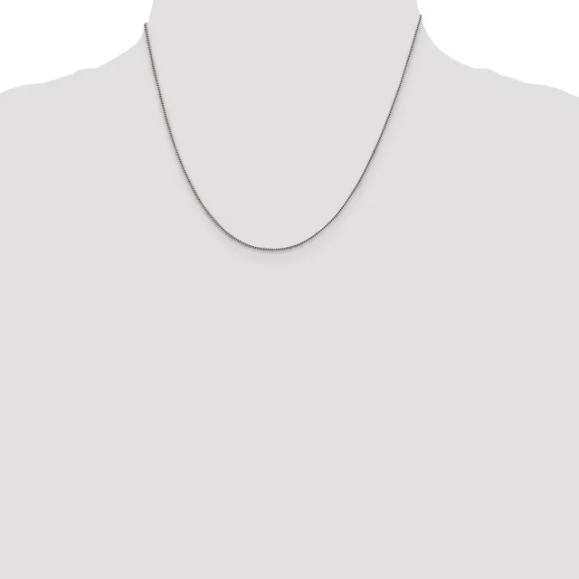 A thin silver chain necklace displayed on a mannequin torso against a white background.