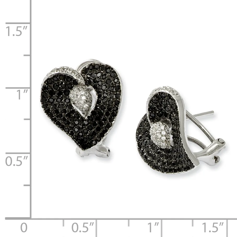 A pair of silver heart-shaped earrings with black gemstones surrounding a white gemstone center, shown against a measurement scale.