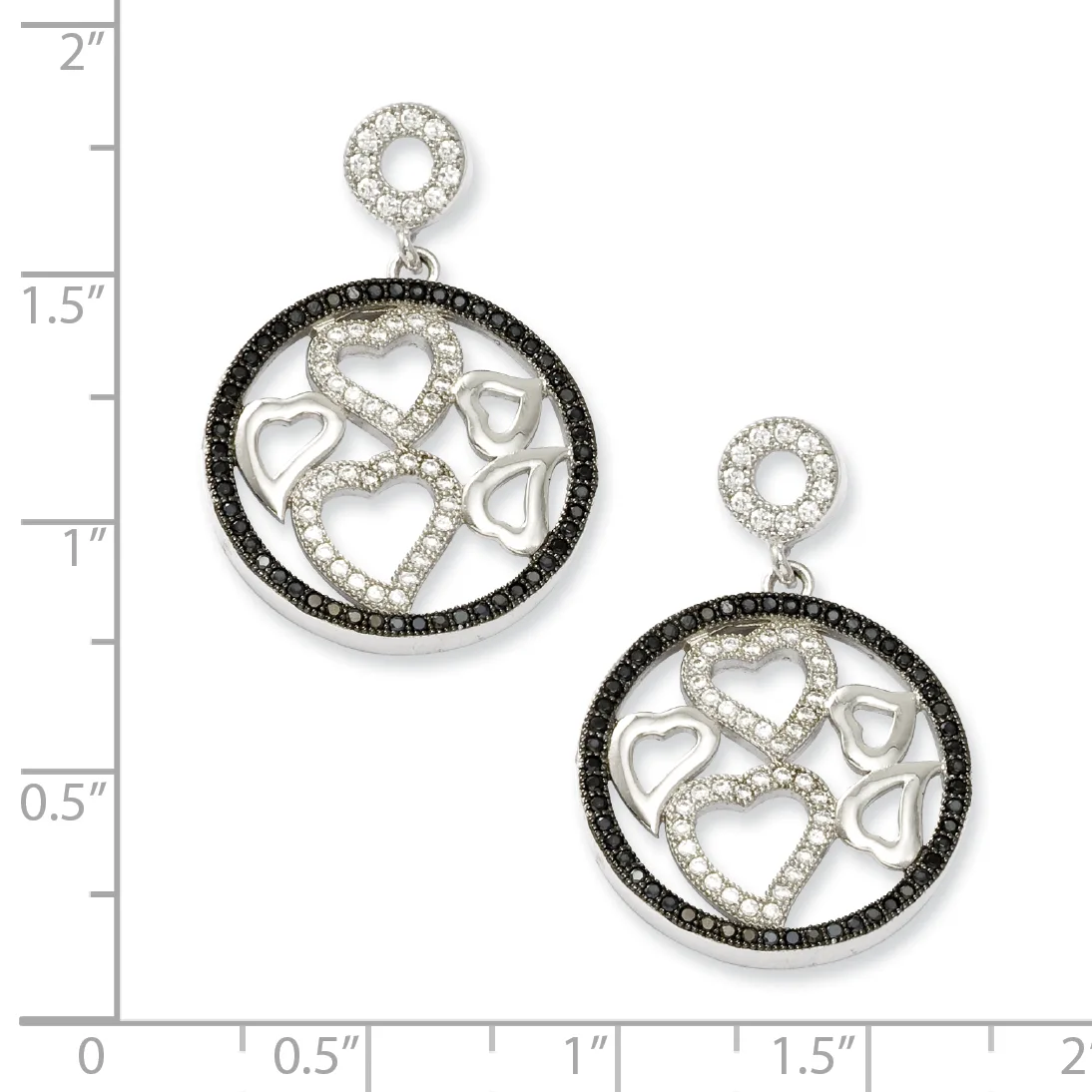 Two silver circular pendant earrings with black and white diamond halos, featuring cutout hearts and infinity symbols, displayed next to a measurement ruler.