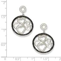 Two silver circular pendant earrings with black and white diamond halos, featuring cutout hearts and infinity symbols, displayed next to a measurement ruler.