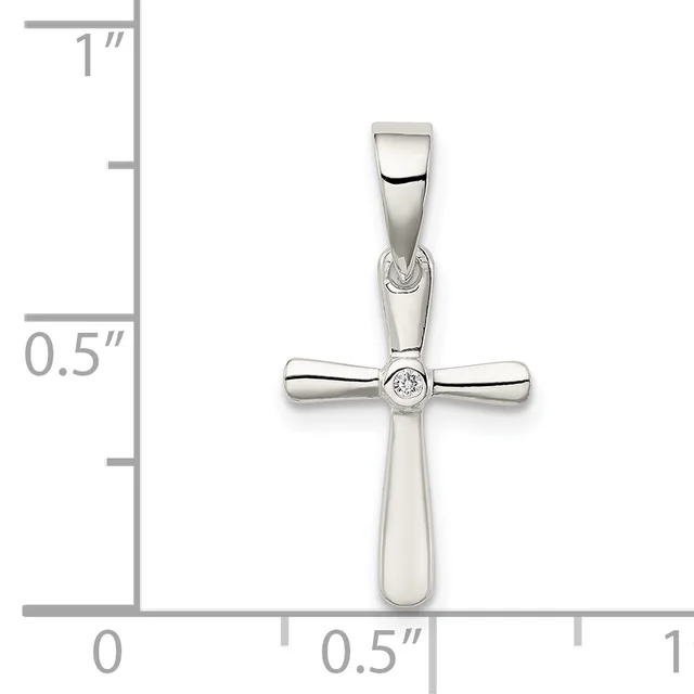 A polished silver cross pendant with a small round diamond at its center, displayed against a measurement scale showing approximately one inch in height.