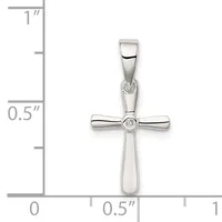 A polished silver cross pendant with a small round diamond at its center, displayed against a measurement scale showing approximately one inch in height.