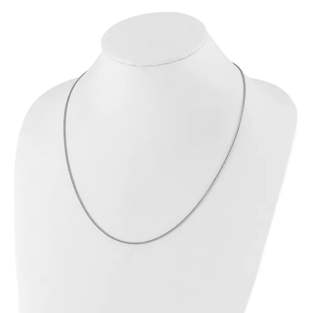 A thin silver chain necklace displayed on a white mannequin bust against a white background.
