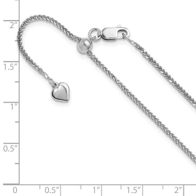 Silver-toned chain bracelet with a small heart charm and lobster clasp, displayed against a measurement ruler showing approximately 2 inches in length.