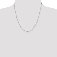 A delicate silver-toned chain necklace with small round beads evenly spaced along its length, displayed on a mannequin bust.