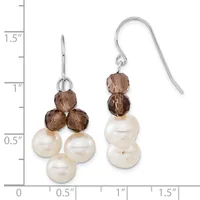 A pair of earrings with smoky quartz faceted beads on top and white pearl beads below, suspended from silver ear wires, displayed next to a measurement ruler.