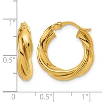 A pair of twisted gold hoop earrings displayed against a measurement scale showing approximately one inch in height and half an inch in width.