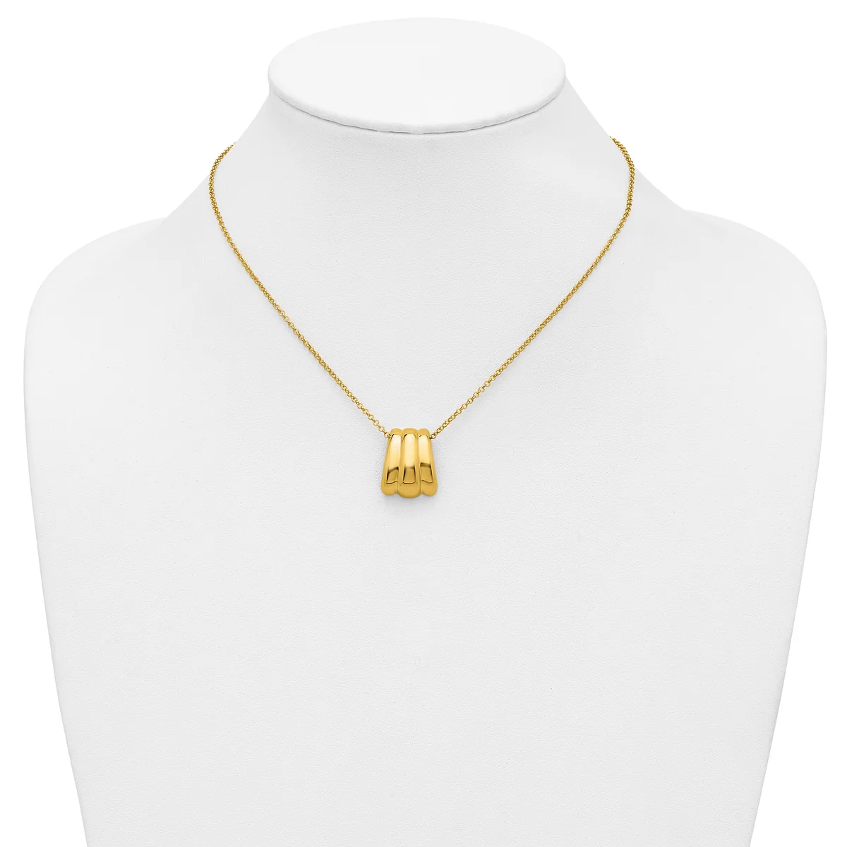 A gold-toned pendant necklace with a ridged cylindrical charm displayed on a white mannequin bust.